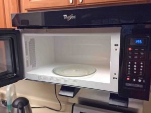 Picture of the Whirlpool Over Range Microwave Oven WMH31017AB2, fully installed with its door open.