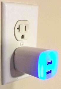 Picture of the GE Jasco Y14 2.1 amp USB wall adapter, plugged in, showing the built in LED night light.