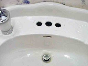 Picture of our bathroom sink with broken faucet removed and the holes cleaned out. 