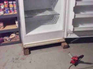Picture of deep freezer defrosting sped up considerably by directing hot air from heat gun or hairdryer into it.