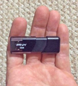Picture of the PNY Attache USB 16 GB pen drive, held in hand, removed from original packaging. 