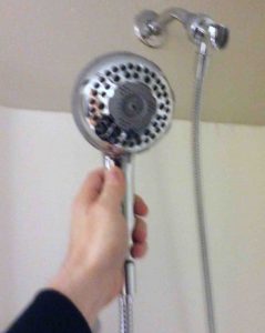 Picture of a Waterpik massaging shower with hose threaded onto it. 