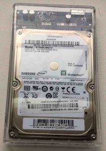 How to recover a hard drive that is clicking. Picture of a Samsung Laptop HDD in USB enclosure, top view.