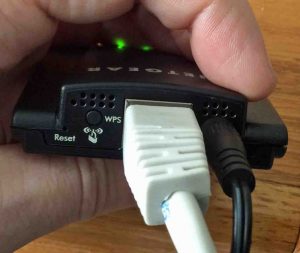 Picture of the Netgear WNCE2001 Universal Internet Adapter, Back View, showing the Ethernet and power ports along with the RESET and WPS buttons. 