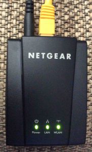 Picture of the Netgear WNCE2001 Universal Internet Adapter, top view, vertical orientation.