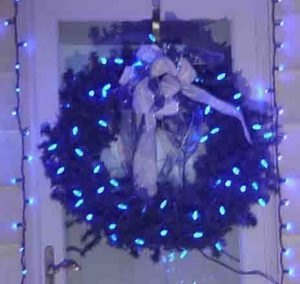 Picture of Blue LED Holiday Lights, decorated wreath hanging on west door at our home. 