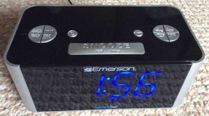 Picture of the Emerson™ CKS1708 SmartSet Clock Radio, top front view, showing blue LED display and the buttons. 