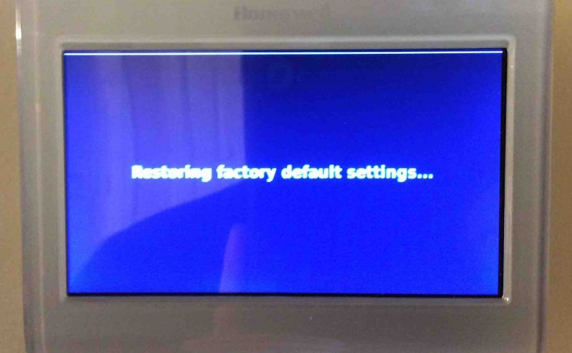 Picture of the Honeywell RTH9580WF Smart Thermostat, displaying the Restoring Factory Default Settings screen during reset.