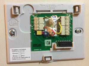Picture of the Honeywell Smart Thermostat RTH9580WF wall plate, mounted, with wires connected.