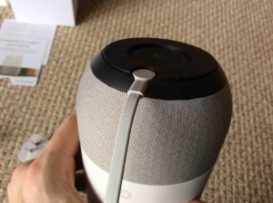 Picture of the Google Home speaker, bottom view, showing the power plug fully inserted into speaker power port.