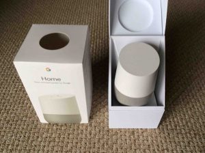Picture of the Google Home smart speaker, front view, with box open.