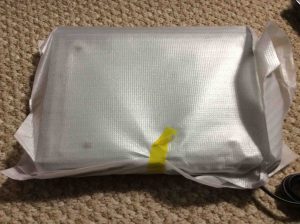 Picture of the Sony DVP-SR210P DVD player, wrapped in protective padding sheet.