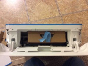 Picture of the printer with inner access panel open, showing box with cords inside.