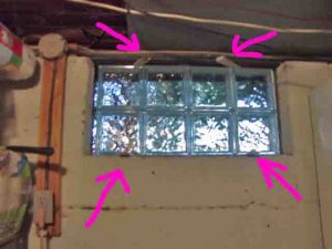 Picture of the basement glass block window replacement 2, positioned and shimmed, with shims highlighted.