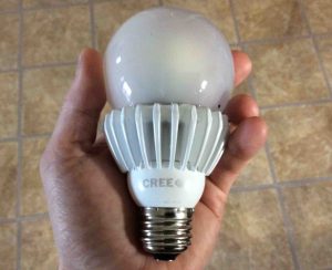 Picture of the Cree™ 100w LED daylight 5000k dimmable A21 light bulb, held in hand.