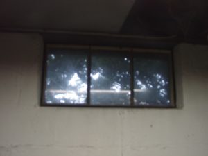 Picture of an old metal framed basement window 1 prior to replacement.