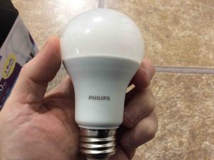 Picture of the Philips LED 100w A19 daylight white light bulb, held in hand.