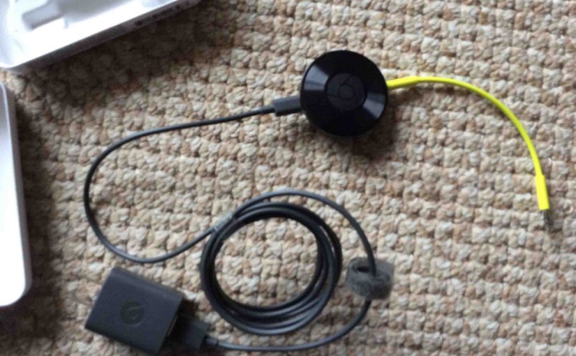 Picture of the Google Chromecast Audio receiver with its audio and power cords connected.