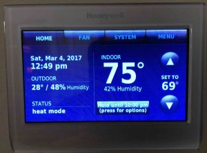 Picture of the Honeywell RTH9580WF wireless thermostat, displaying its -Home- screen, with the temperature set to 69 degrees, and in temporary hold until 10:00 PM.