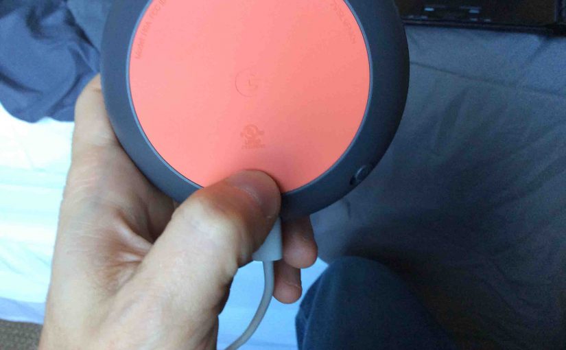 Picture of the Google Mini speaker with its Reset button held in.