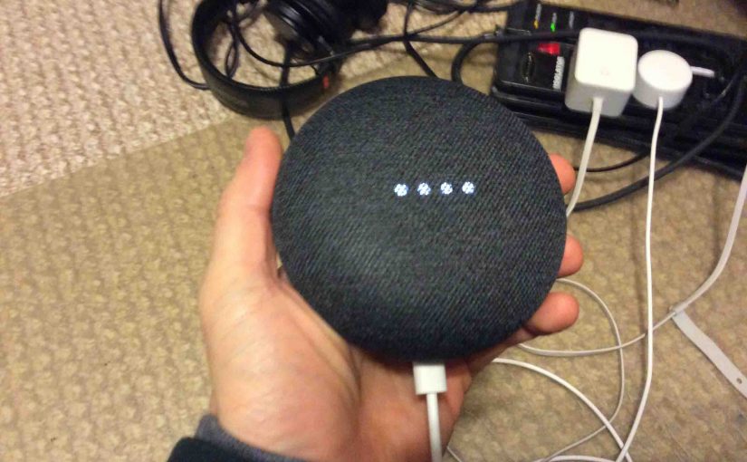 Picture of the Google Home Mini speaker, in setup mode, displaying the dimming white lights across the top.