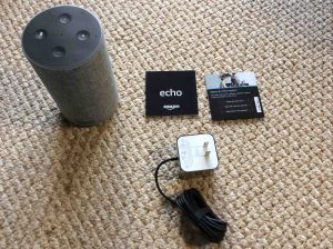 Picture of the Amazon second generation Echo speaker with all accompanying accessories unboxed.