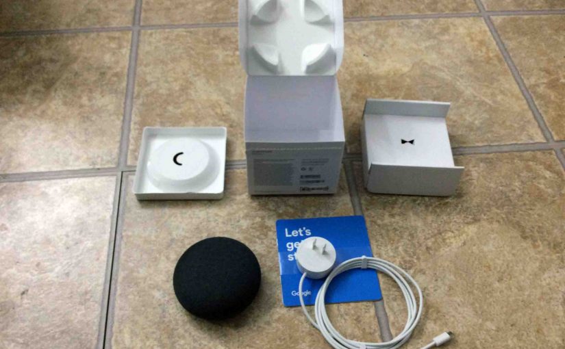 Picture of the Google Home Mini smart speaker, oiginal box, and included accessories, completely unpacked.