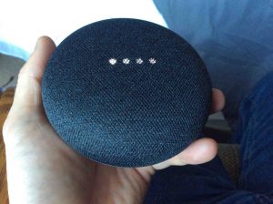 Picture of the Google Home Mini speaker rebooting, showing white scanning lights pattern.