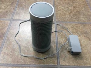 How to reboot Harman Kardon Invoke voice activated speaker. Picture of the Microsoft Invoke Cortana smart speaker, with its AC adapter unplugged from wall and powered off, prior to rebooting.