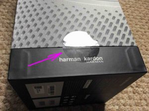 Picture of the Harman Kardon Invoke speaker, new in box, showing the sealing tape.