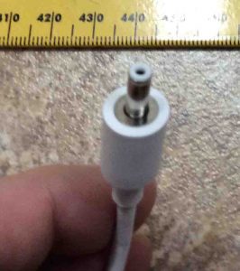 Picture of the adapter, showing the DC output barrel connector hole, top view, against a ruler.