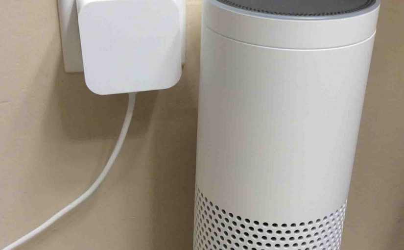 Picture of the Amazon Alexa Echo Gen 1 smart speaker with its AC power adapter plugged in.