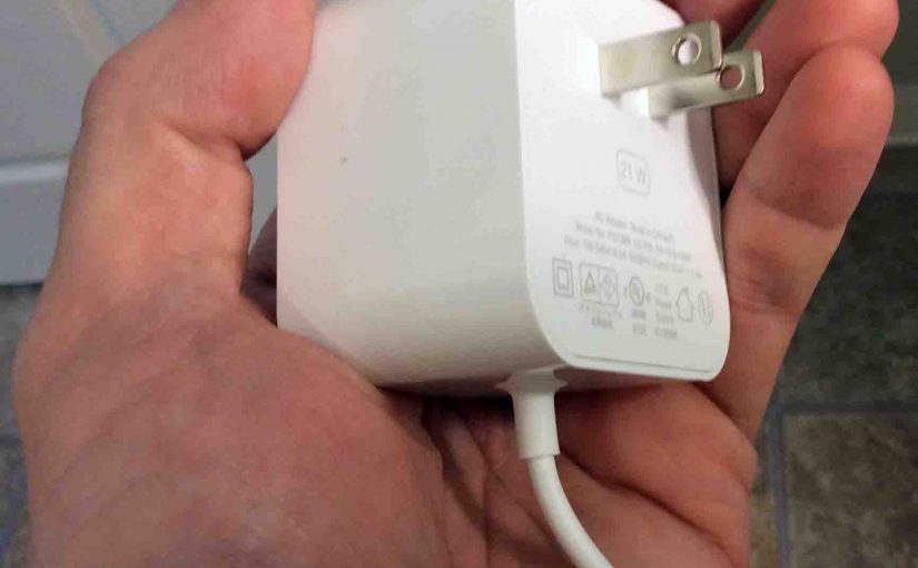 Picture of the Amazon Alexa Echo Generation 1 smart speaker AC power adapter, showing the wall part, held In hand.