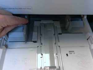 Picture of the Color Laser Jet Pro MFP M477 printer, showing adjustment of paper width in lower paper tray.