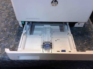 Picture o fthe HP color Laserjet pro MFP M477 series printer, front view, showing lower paper tray open.