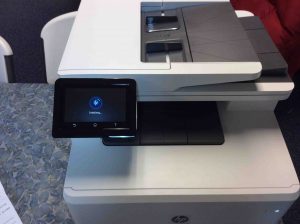Picture of the Laserjet MFP M477 printer, front view, showing -Initializing- screen.