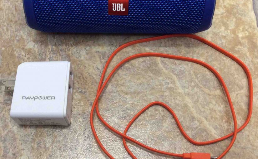 Picture of the JBL Flip 4 portable speaker with a RavPower USB charger and micro USB charge cable.
