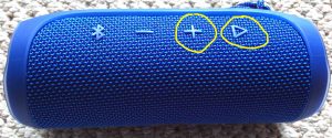 Picture of the JBL Flip 4 Bluetooth speaker. Showing the Volume UP and Play-Pause buttons circled in yellow.