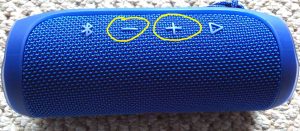 Picture of the JBL Flip 4 Bluetooth speaker. Showing the Volume UP and DOWN buttons circled in yellow.