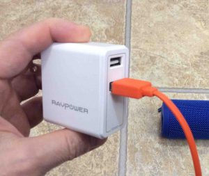 Picture of the RavPower portable USB charger with a micro USB cable plugged into one of its dual USB ports.