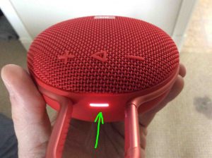 Picture of the JBL Clip 3 Bluetooth speaker, top view, showing the status lamp glowing shite and highlighted.