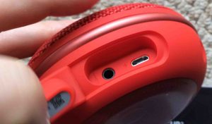 Picture of the JBL Clip3 waterproof speaker, bottom view, showing the port door open, USB charge and audio in ports.