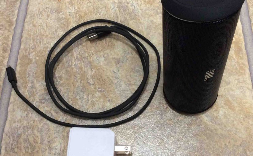 Picture of the JBL Flip 2 portable Bluetooth speaker with a RavPower charger and USB power cable.