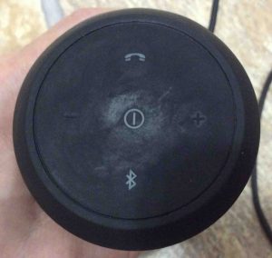 Picture of the JBL Flip 2 wireless speaker, showing the control buttons end. The speaker is powered Off. No lamps lit.
