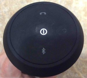 Picture of the JBL Flip 2 wireless speaker, showing its control button side. The speaker is powered On but not paired. The Bluetooth button is dark. 
