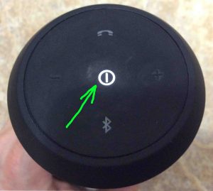 Picture of the JBL Flip 2 wireless speaker, powered ON, with its Power button highlighted.