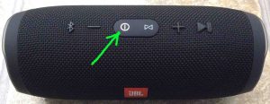 Picture of the speaker powered On, not paired. Showing the glowing white power button highlighted.