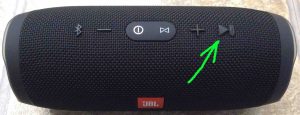 Picture of the JBL Charge 3 waterproof portable speaker. Showing its Play-Pause button highlighted.