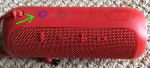 Picture of the JBL Flip 3 battery powered Bluetooth speaker, showing its power button glowing blue. JBL Flip 3 Bluetooth wireless speaker, red version, front view. Pairing JBL Flip 3 splashproof speaker with Victor Reader Trek.