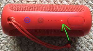 Picture of the JBL Flip 3 Bluetooth speaker, its battery status indicator showing that the internal battery is almost completely dead. The red light, showing that the battery is critically low, is highlighted.